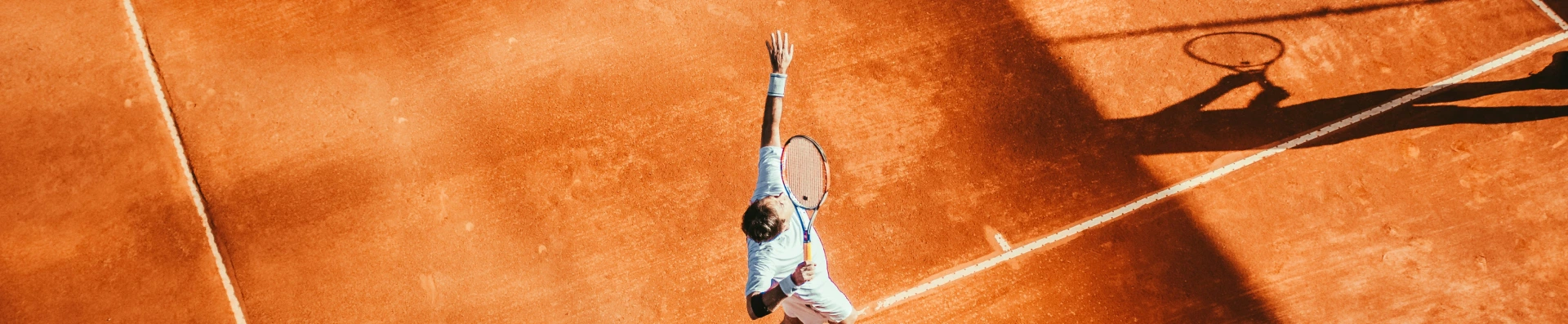 Tennisspiller server under US Open-sæsonen på en grusbane